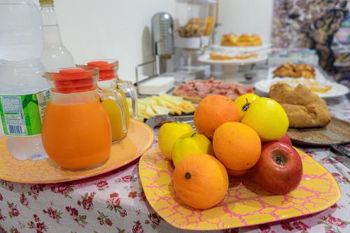 a table topped with plates of fruit and pitchers of juice at Profumi di Primavera Luxury Rooms & Suite in Matera