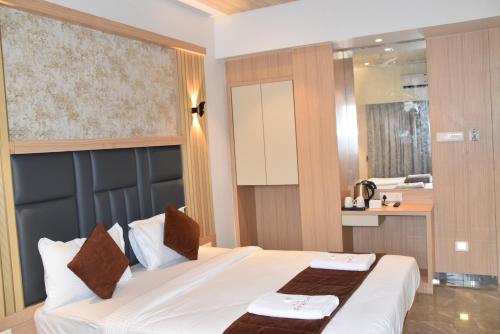 a hotel room with a bed and a bathroom at Hotel Aarush Inn in Navi Mumbai