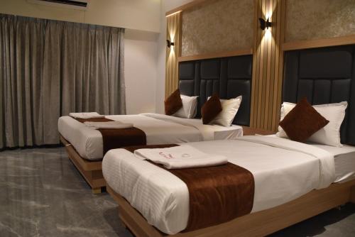 a hotel room with two beds in a room at Hotel Aarush Inn in Navi Mumbai