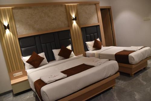 two beds in a hotel room with two at Hotel Aarush Inn in Navi Mumbai