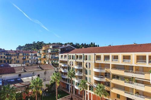 une vue aérienne sur un bâtiment avec des palmiers et des bâtiments dans l'établissement Port Nicea Residence, à Nice