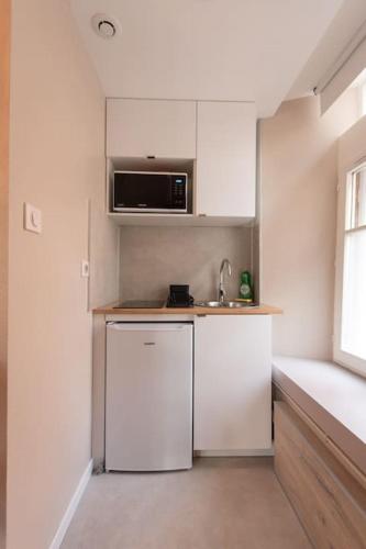 une petite cuisine avec un évier et un réfrigérateur dans l'établissement La Parenthèse - Studio près de la Petite France, à Strasbourg