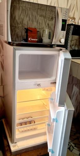 an open refrigerator with its door open and a microwave at Mini Studio Meublé venez loger ici in Dakar