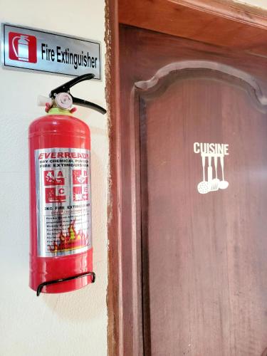 a fire extinguisher hanging on a wall next to a door at Mini Studio Meublé venez loger ici in Dakar