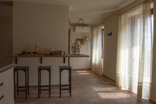 a kitchen with a counter and stools in a room at ByVigin in Magliano Alfieri