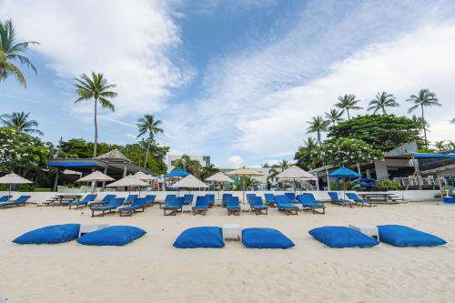 a group of blue beach chairs and umbrellas on a beach at KC Beach Club & Pool Villas in Chaweng