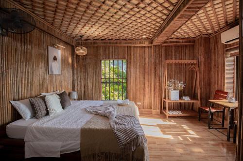 a bedroom with a bed in a room with wooden walls at Bamboo Hill Villa in Ninh Binh