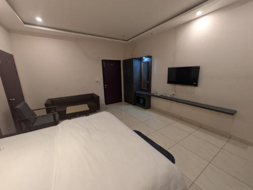 a hotel room with a bed and a tv at Kishori Vatika in Rāmnagar