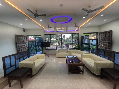 a large living room with couches and a tv at Kishori Vatika in Rāmnagar