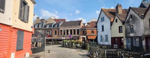 une rue dans une ville avec des maisons et des bâtiments dans l'établissement Les Hortensias Blancs Studio, à Amiens