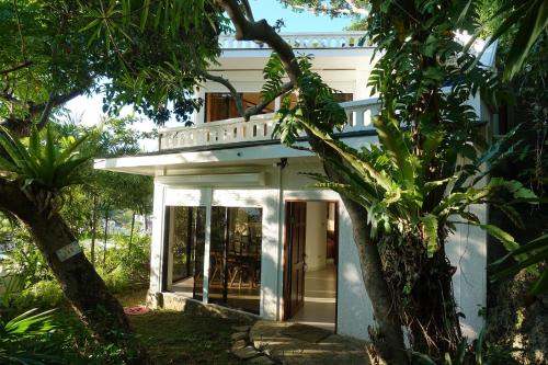 a white house with trees in front of it at Argonauta Boracay Apartment Suites and Villas in Boracay