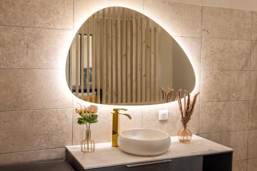 une salle de bain avec un lavabo et un miroir dans l'établissement Suite de Prestige le Diamant - 55m2, à Périgueux