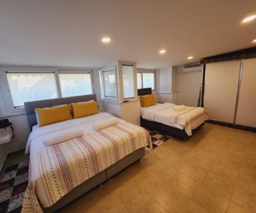 a bedroom with two beds in a room with windows at Villa De Papel in Belek
