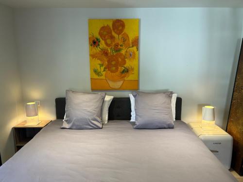 a bed with two pillows and a painting on the wall at DURANCE in La Brillanne