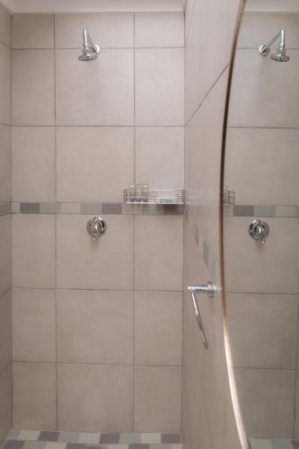 a shower with a glass door in a bathroom at Dolliwarie Guesthouse in Panorama