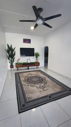 a living room with a ceiling fan and a rug at Homestay Cinta Kasih Mus'lim Only in Klang