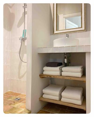 La salle de bains est pourvue d'un lavabo et d'un tas de serviettes. dans l'établissement Maison 15 pers dans le Perche avec Piscine, à Saint-Aubin-des-Grois