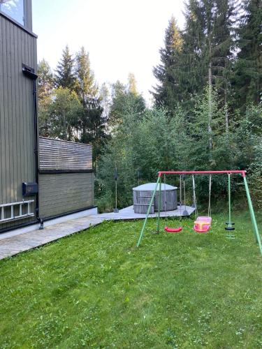 a yard with a swing set in the grass at En perle på Gjøvik, nær populær strand ved Mjøsa in Gjøvik