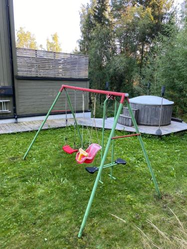 a swing set in a yard with a tub at En perle på Gjøvik, nær populær strand ved Mjøsa in Gjøvik