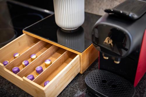 une boîte de chocolats à côté d'une machine à café dans l'établissement Appartement de Prestige Emeraude 60m2, à Périgueux