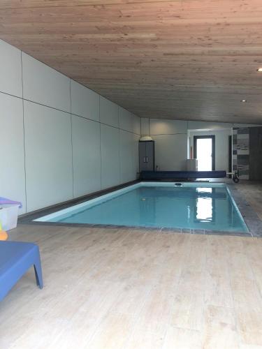 - une grande piscine dans une chambre dotée d'un plafond en bois dans l'établissement Gîtes TiArMein, à Guissény