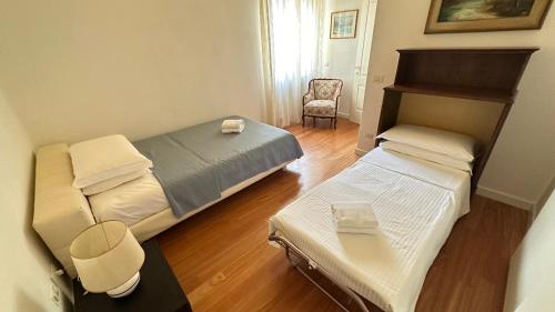 a small room with two beds and a chair at Pang's Home in Marghera