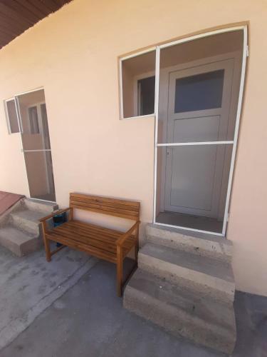 a wooden bench sitting next to a building with a door at Vila Dionysos Brasov in Braşov