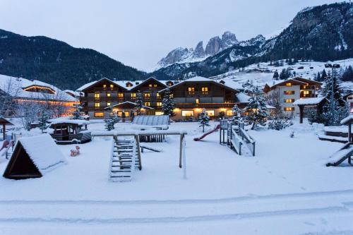 a lodge in the snow in the mountains at Hotel Sella Ronda Serenella in Campitello di Fassa