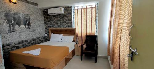a bedroom with a bed and a picture of an elephant at Srirathna Temple View Inn in Thanjāvūr