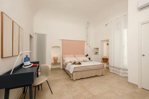 une chambre avec un lit, un bureau et un piano dans l'établissement I ricami di Annina, à Castellana Grotte