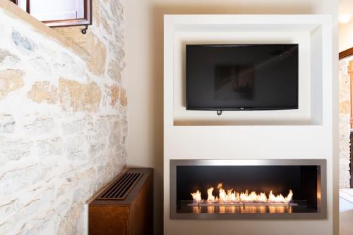 a living room with a fireplace with a tv above it at Tenute Baglio Passofondo in Alcamo