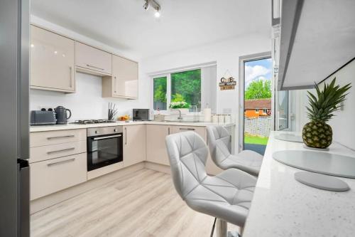 a kitchen with white cabinets and a table and chairs at Witton Lodge 3 Bedroom House - Long Stay Offers in Birmingham