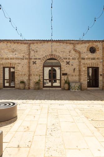 a large brick building with a large courtyard at Tenute Baglio Passofondo in Alcamo