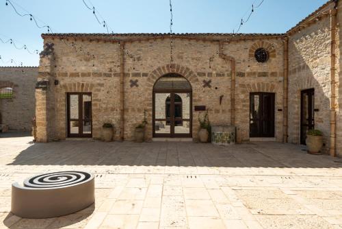 a large brick building with a sculpture in the courtyard at Tenute Baglio Passofondo in Alcamo