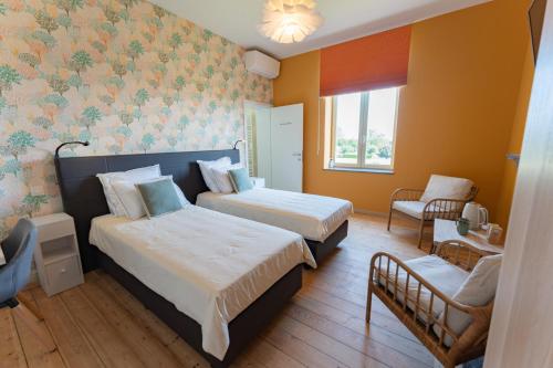 a hotel room with two beds and a chair at Manoir du Moulin in Berloz