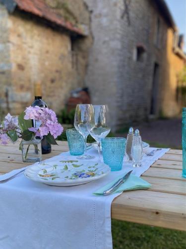 - une table avec une assiette et des verres à vin dans l'établissement Les Pommiers d'Amfreville, Chambres d'hôtes & Table d'hôtes, à Picauville
