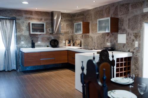a kitchen with a refrigerator and a table in it at Casa dos Chuchos in Cabanas de Viriato
