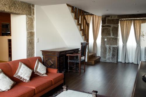 a living room with a couch and a desk at Casa dos Chuchos in Cabanas de Viriato