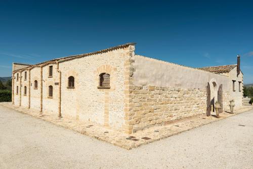 an old brick building on a dirt road at Tenute Baglio Passofondo in Alcamo