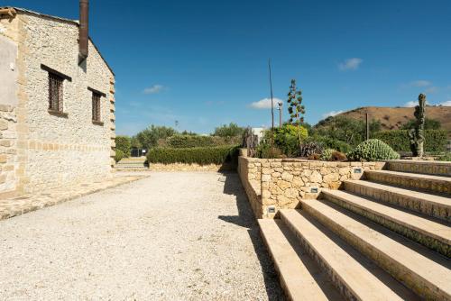 a stone wall and stairs next to a building at Tenute Baglio Passofondo in Alcamo