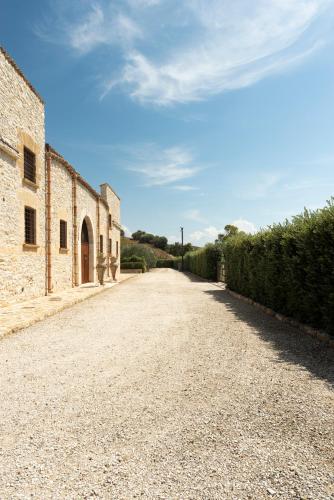 an empty road next to a brick building at Tenute Baglio Passofondo in Alcamo