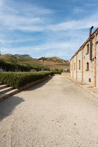an empty road next to an old brick building at Tenute Baglio Passofondo in Alcamo