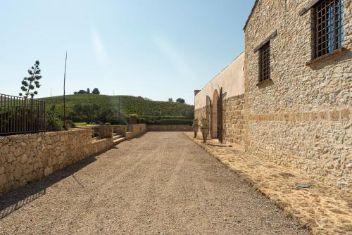an alley between a stone wall and a building at Tenute Baglio Passofondo in Alcamo