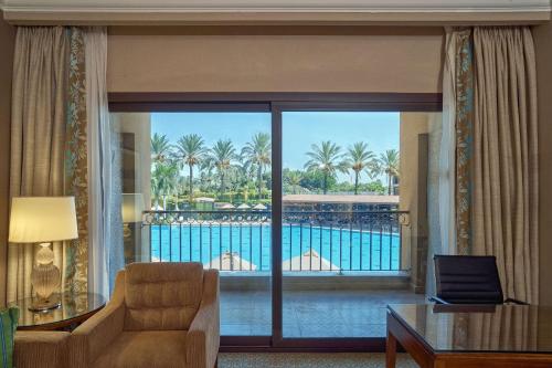 a living room with a view of a balcony at Hilton Alexandria King's Ranch Hotel in Alexandria