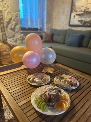 four plates of food on a wooden table with balloons at Kandybos Eco Farm Village in Kas