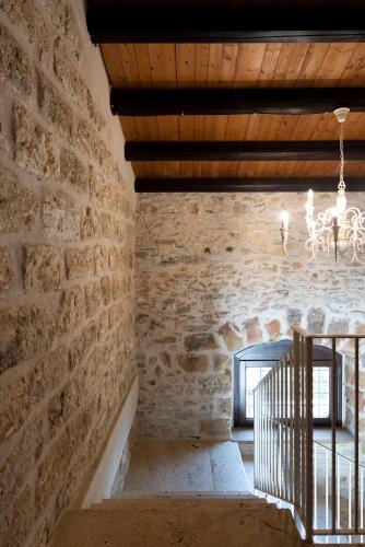 a room with a stone wall and a staircase at Tenute Baglio Passofondo in Alcamo