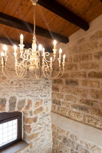 a chandelier hanging from the ceiling of a stone wall at Tenute Baglio Passofondo in Alcamo