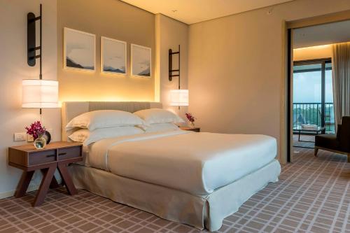 a bedroom with a large bed and a desk with a night stand at Grand Hyatt Rio de Janeiro in Rio de Janeiro