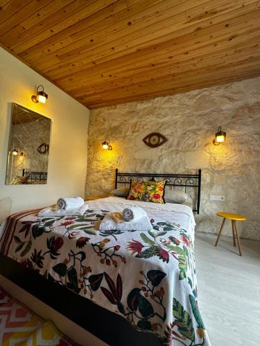 a bedroom with a bed in a stone wall at Kandybos Eco Farm Village in Kas
