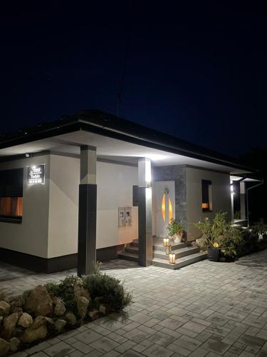 a small house with a lit up room at night at Anna Vendégház Sárospatak in Sárospatak